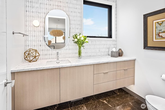 1721 J B George Rd, Walla Walla, WA 99362 - bathroom featuring marble look tiles, vanity, toilet, and baseboards