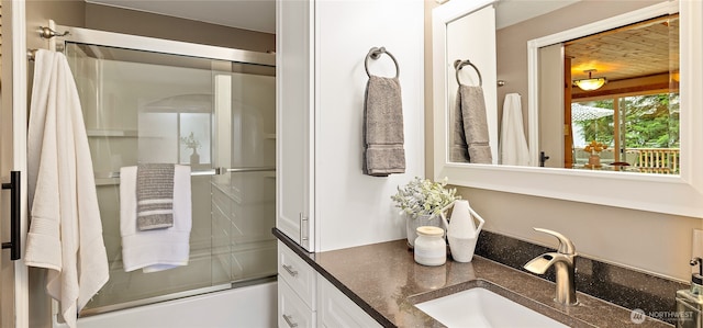 bathroom with combined bath / shower with glass door and vanity