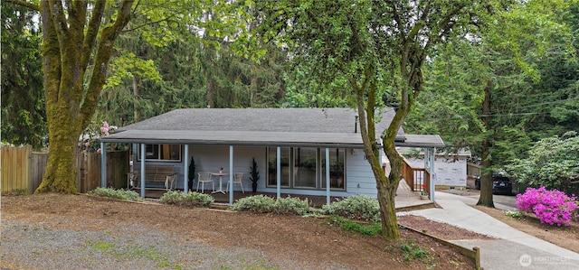 single story home with a porch, fence, and roof with shingles