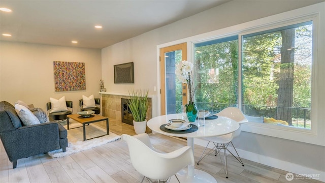 living area with light wood-style floors, recessed lighting, and a tile fireplace