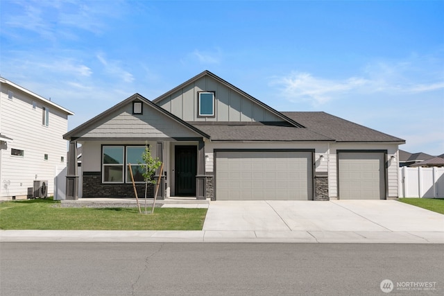 craftsman-style house with a garage, board and batten siding, a front yard, and concrete driveway