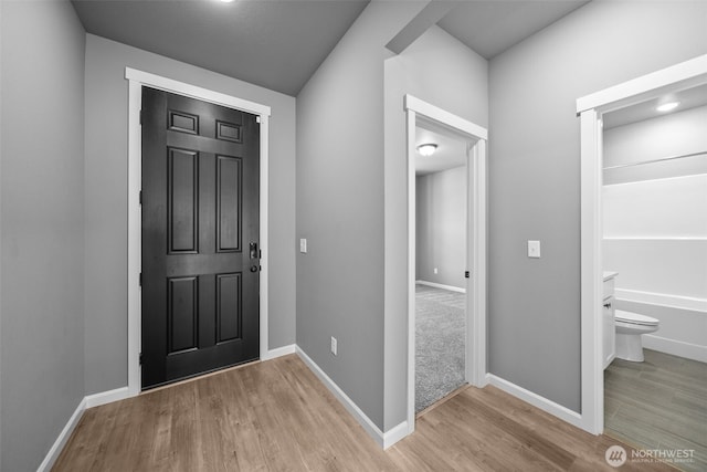 entrance foyer with baseboards and wood finished floors