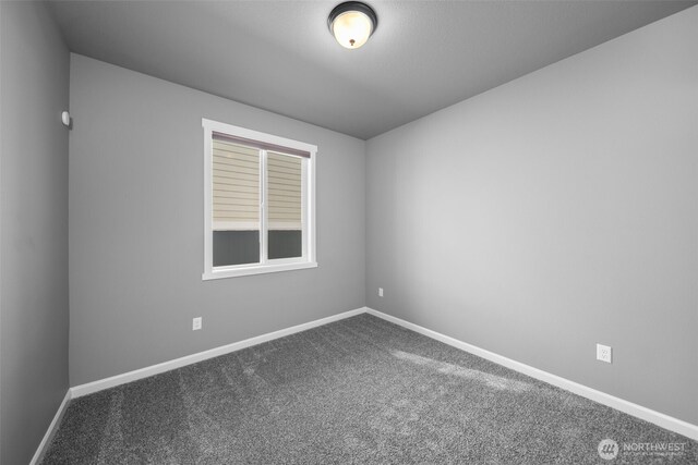carpeted spare room featuring baseboards