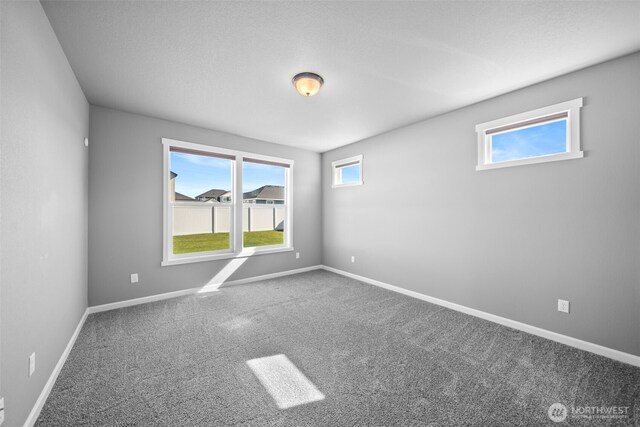 unfurnished room featuring carpet flooring and baseboards
