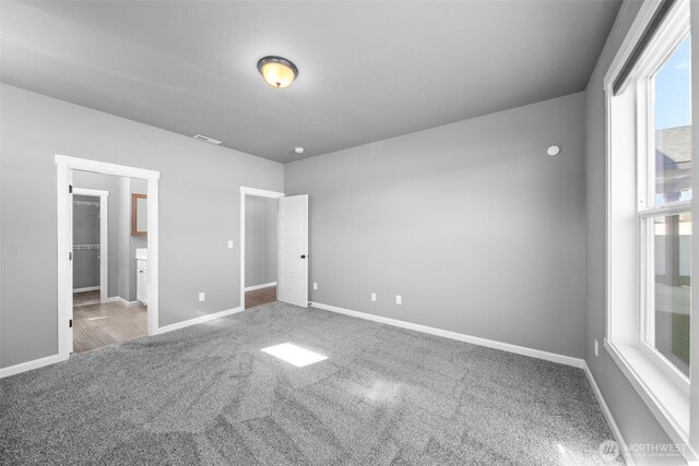 unfurnished bedroom featuring visible vents, carpet flooring, and baseboards
