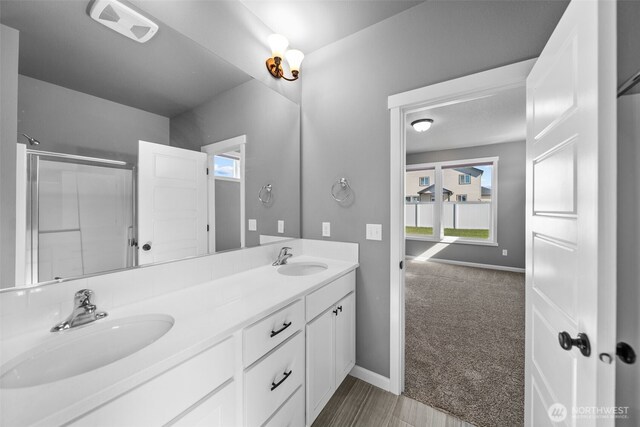 full bathroom featuring a sink, a shower with door, double vanity, and visible vents