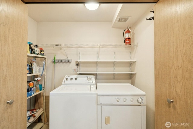 washroom featuring laundry area, washer and dryer, and visible vents