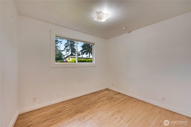 unfurnished room featuring wood finished floors and baseboards