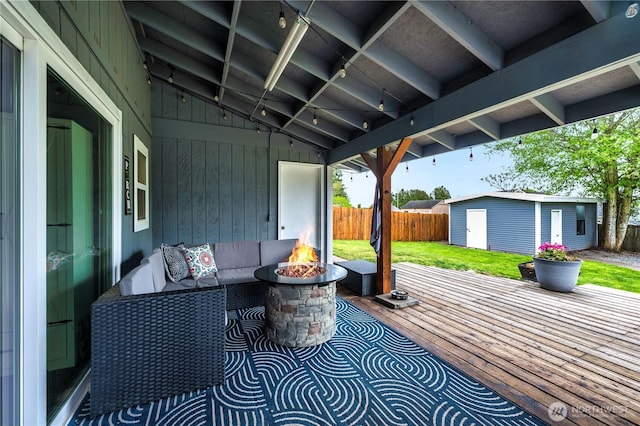 view of patio featuring an outdoor fire pit, a storage unit, and an outbuilding