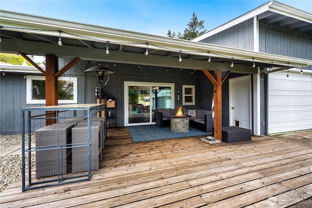 wooden terrace with an outdoor living space with a fire pit