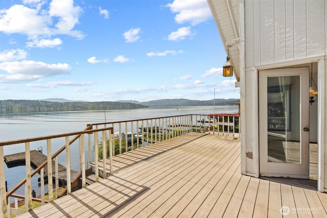 wooden terrace with a water and mountain view