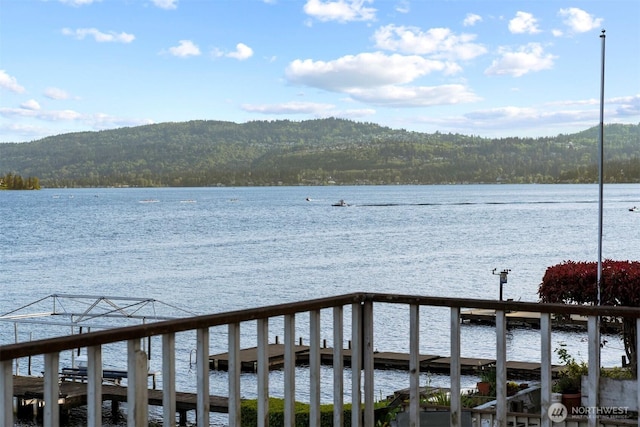 view of dock with a view of trees and a water and mountain view