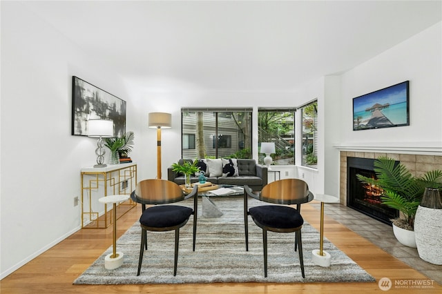 sitting room featuring baseboards, a fireplace, and wood finished floors
