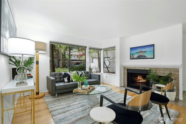 living area with a tiled fireplace and wood finished floors