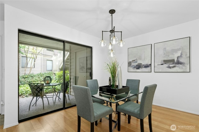 dining space featuring baseboards and light wood finished floors