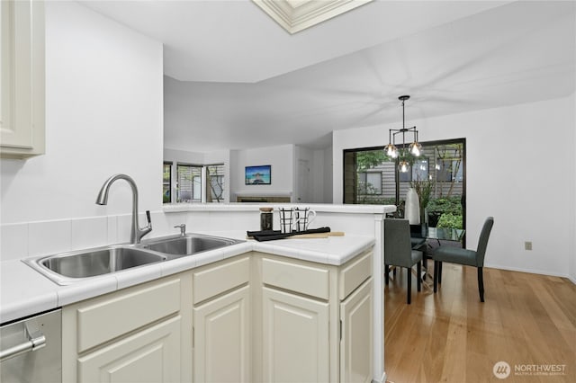 kitchen featuring a sink, dishwasher, a peninsula, and a healthy amount of sunlight