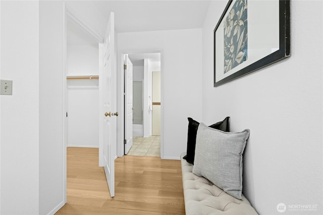 hall with baseboards and light wood-type flooring