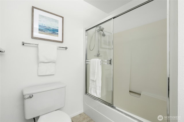 full bathroom featuring toilet and bath / shower combo with glass door