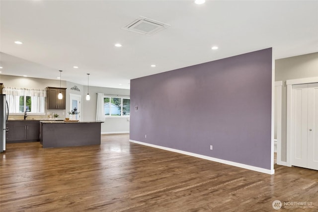 unfurnished living room with visible vents, recessed lighting, and dark wood-style flooring