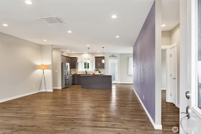 kitchen featuring a center island, open floor plan, dark wood-style floors, and stainless steel fridge with ice dispenser