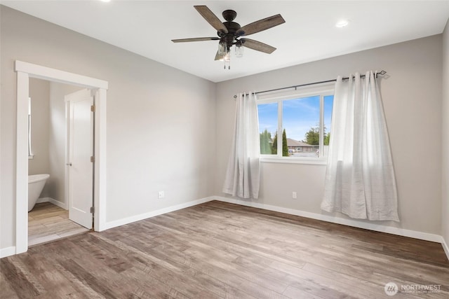 unfurnished bedroom featuring ceiling fan, ensuite bath, recessed lighting, baseboards, and wood finished floors