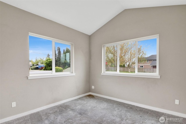 carpeted empty room with baseboards and vaulted ceiling