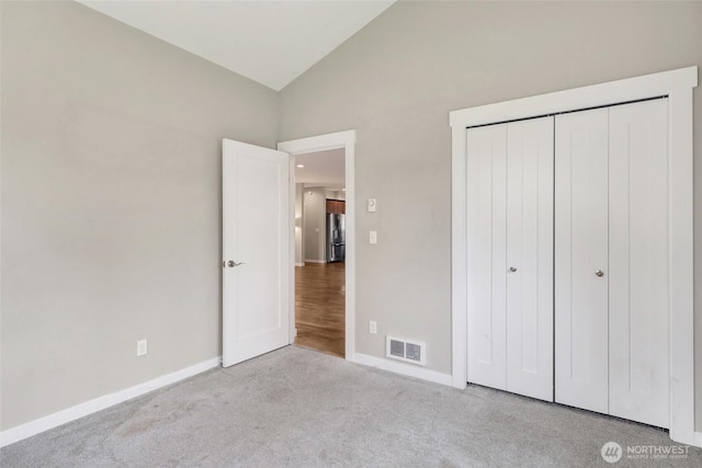 unfurnished bedroom featuring baseboards, carpet flooring, visible vents, and stainless steel fridge