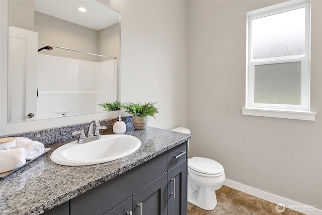 full bathroom with toilet, baseboards, a shower, and vanity