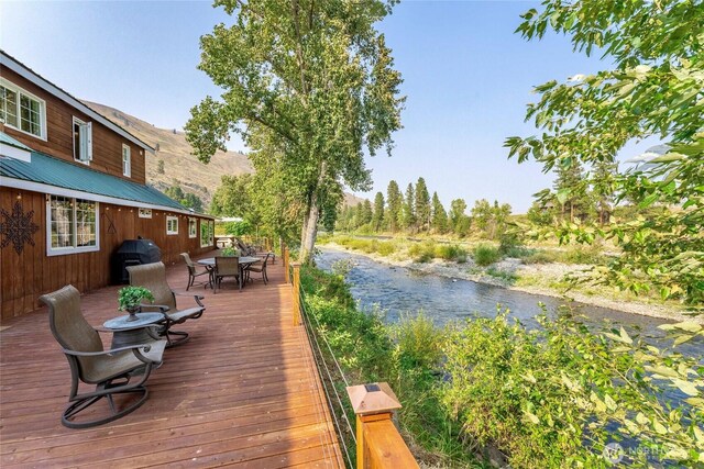 wooden terrace with a mountain view and outdoor dining area
