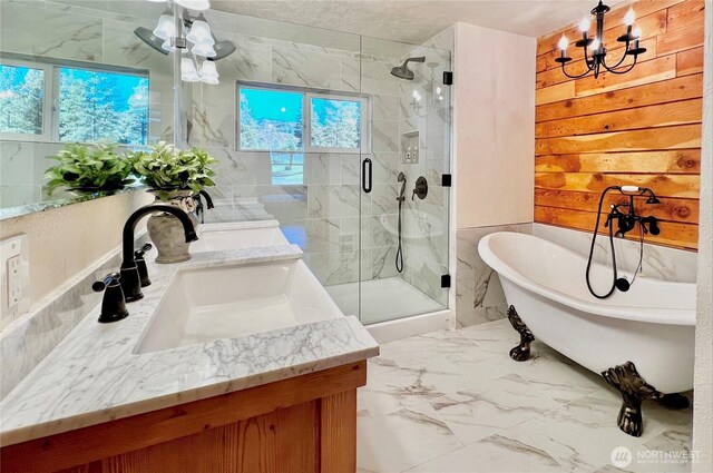 bathroom featuring an inviting chandelier, vanity, marble finish floor, a shower stall, and a soaking tub