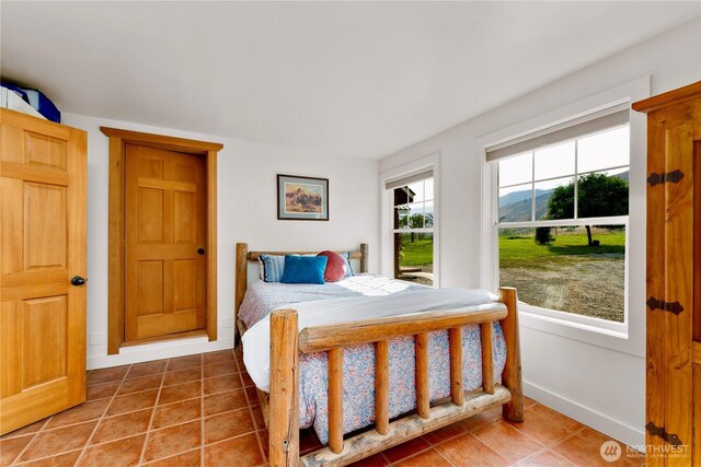 tiled bedroom featuring baseboards