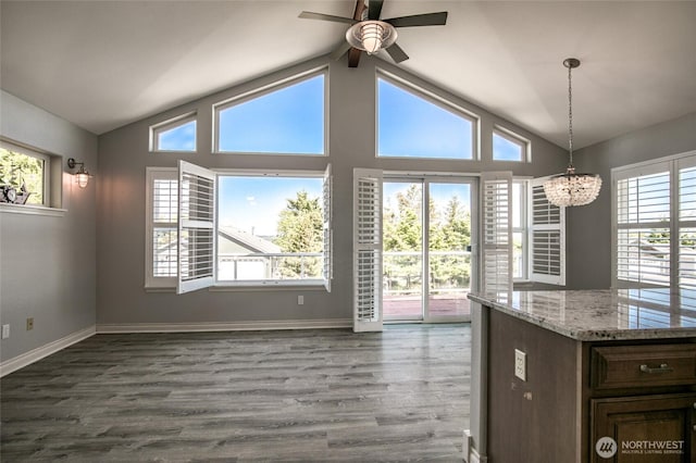 659 Chinook Ave SE, Ocean Shores, WA 98569 - unfurnished dining area featuring ceiling fan, a chandelier, dark wood finished floors, and plenty of natural light