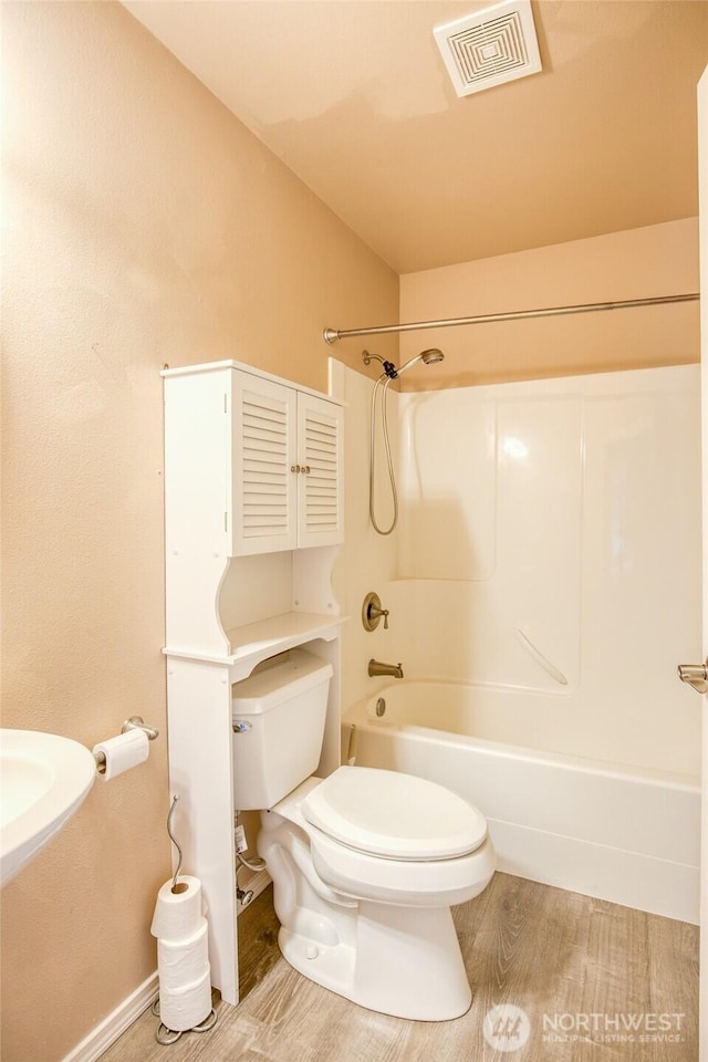 659 Chinook Ave SE, Ocean Shores, WA 98569 - full bathroom featuring toilet, shower / bathtub combination, and wood finished floors