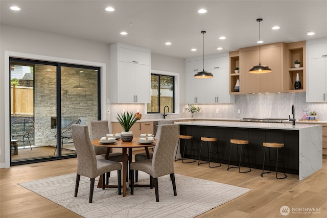 dining space with light wood-type flooring and recessed lighting