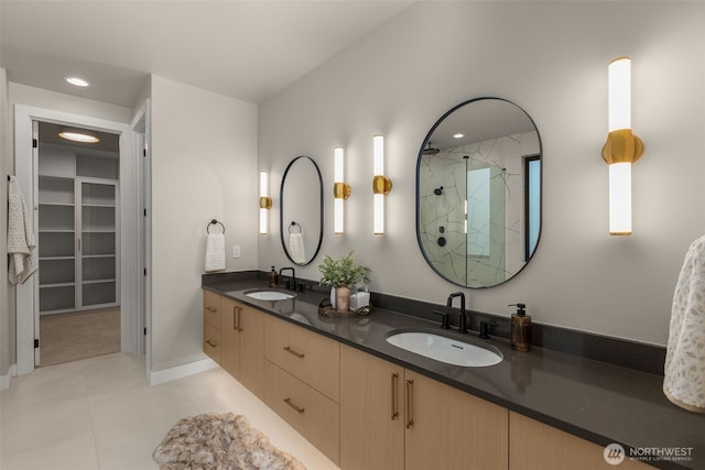 full bathroom with a sink, double vanity, a stall shower, and tile patterned floors