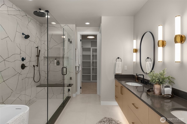 full bathroom with double vanity, a marble finish shower, a sink, tile patterned flooring, and recessed lighting