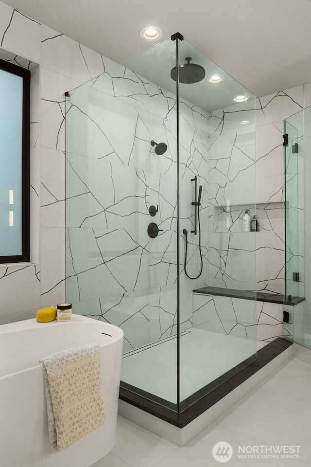 bathroom featuring a freestanding bath, a marble finish shower, and recessed lighting