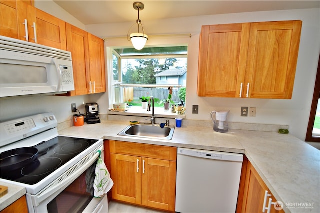 kitchen featuring a sink, light countertops, hanging light fixtures, and white appliances