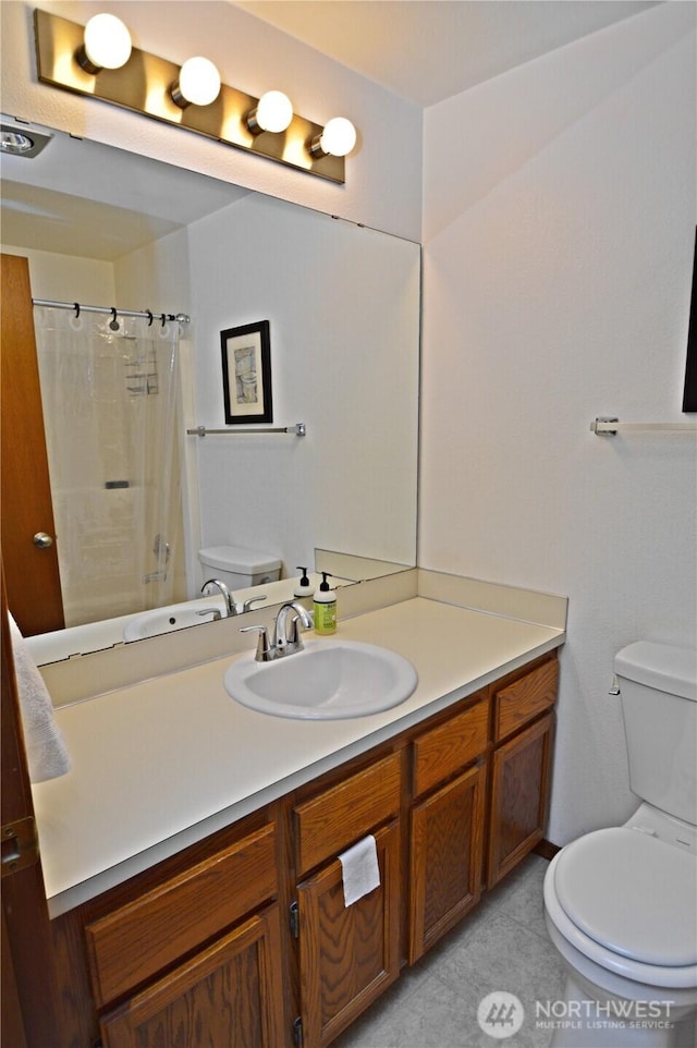 bathroom with vanity, tile patterned floors, toilet, and curtained shower