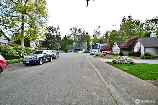 view of road featuring curbs, sidewalks, and a residential view