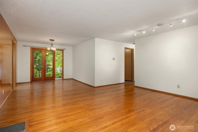 10210 NE 23rd St, Bellevue, WA 98004 - spare room with baseboards, light wood finished floors, a textured ceiling, and a chandelier