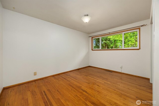 10210 NE 23rd St, Bellevue, WA 98004 - spare room featuring baseboards, visible vents, and wood finished floors