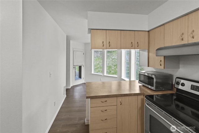 kitchen with light brown cabinetry, appliances with stainless steel finishes, dark wood finished floors, a peninsula, and under cabinet range hood