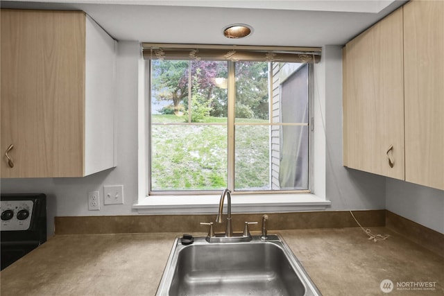 kitchen featuring a sink, electric range, and light brown cabinetry