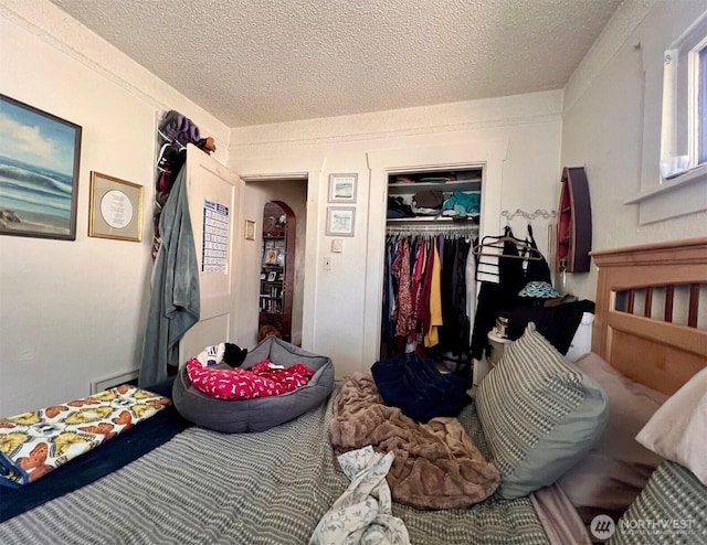 bedroom with arched walkways, carpet, a closet, and a textured ceiling