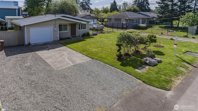 ranch-style house with fence, an attached garage, driveway, and a front yard