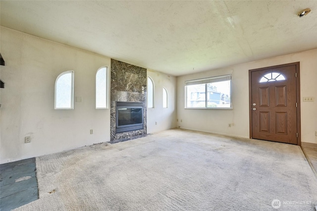 unfurnished living room featuring carpet and a tile fireplace