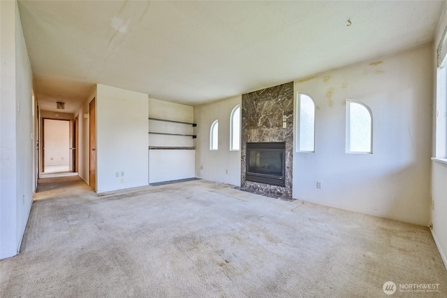unfurnished living room with carpet flooring and a fireplace