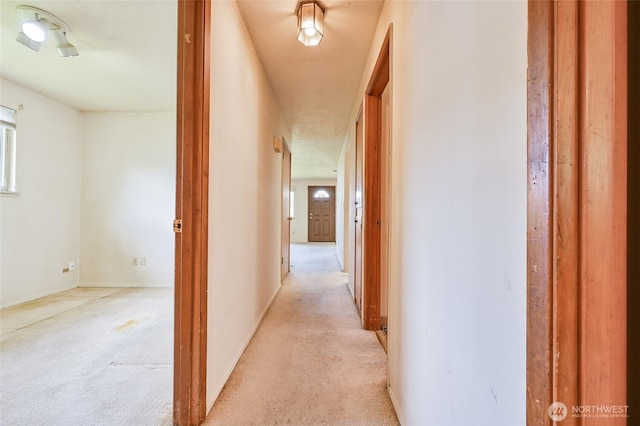 hall with light colored carpet
