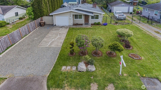 bungalow-style house with driveway, a fenced backyard, a front yard, and a garage